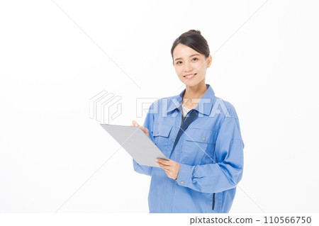 A woman wearing work clothes holding documents 110566750