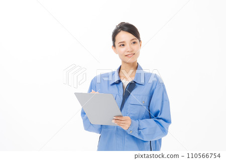 A woman wearing work clothes holding documents 110566754