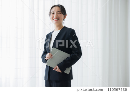 Smiling business woman with a laptop 110567586