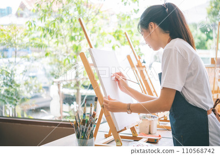 Art student drawing with watercolor painting on canvas doing some art projects on studio workshop 110568742