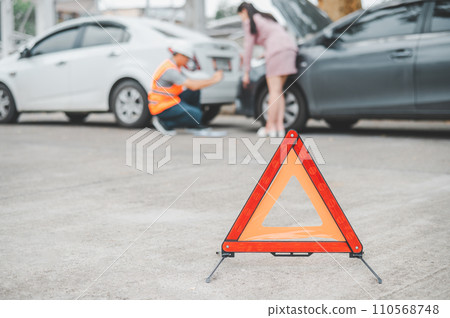 red emergency triangle on the road indicates that there is an accident or car breakdown on the road ahead. red emergency triangle on the road indicates that there is an accident or car breakdown on the road ahead. 110568748
