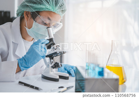 female medical researcher looking at a microscope in a medical laboratory. Medical experimental concept.. female medical researcher looking at a microscope in a medical laboratory. Medical experimental concept.. 110568756