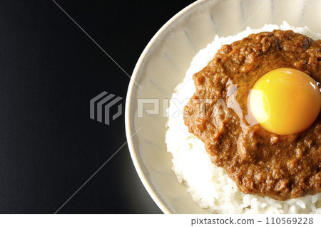 黑色背景下，上面放著蛋黃的 keema 咖哩的俯視圖 110569228