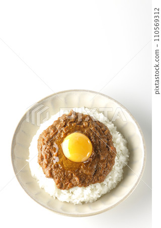 An overhead shot of keema curry topped with egg yolk against a white background 110569312