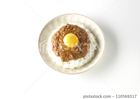 An overhead shot of keema curry topped with egg yolk against a white background 110569317