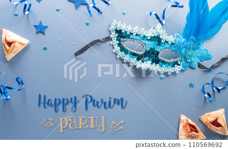 Happy Purim carnival decoration concept made from mask and sparkle star and hamantaschen cookies on pastel background. (Happy Purim in Hebrew, jewish holiday celebrate) 110569692