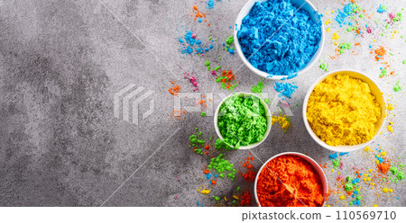 Happy Holi decoration, the indian festival.Top view of colorful holi powder on dark stone background. Happy Holi decoration, the indian festival.Top view of colorful holi powder on dark stone background. 110569710