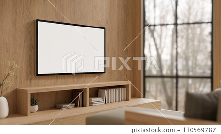 A modern white TV monitor mockup on a wooden wall in a modern, expensively furnished living room. A modern white TV monitor mockup on a wooden wall in a modern, expensively furnished living room. 110569787