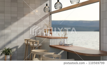 A beautiful dining table is near the large glass window with a lake view in a modern, luxury room. 110569799