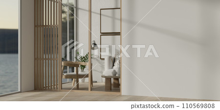 A modern, minimal white-furnished living room with an empty white wall and a parquet floor. 110569808