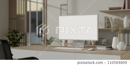 A minimalist white Scandinavian office room with a white-screen PC computer mockup on a wooden table 110569809