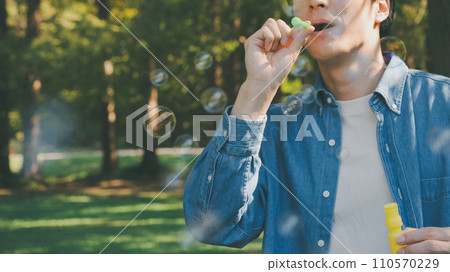 Men blowing soap bubbles Men blowing soap bubbles 110570229