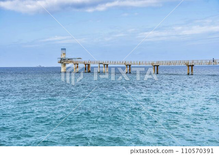 沖繩縣名護市Busena Marine Park的白色沙灘和藍色大海、水下觀測塔和橋樑 110570391
