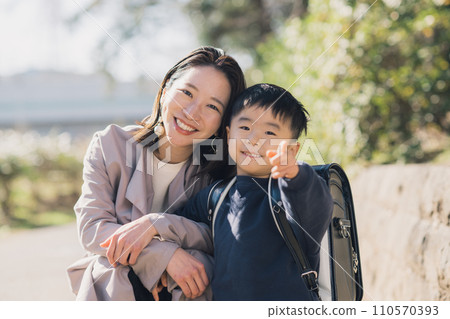 Young mother and boy carrying a school bag 110570393