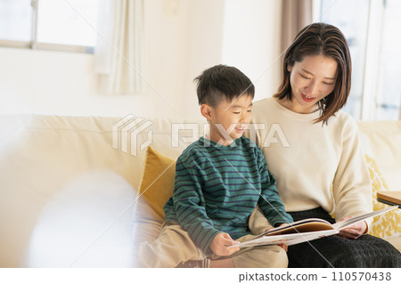 Young mother and boy reading picture books together 110570438