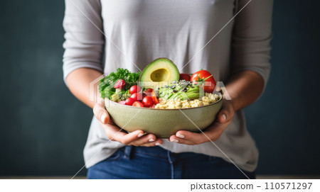 A woman in a t-shirt and jeans standing and holding a vegan food A woman in a t-shirt and jeans standing and holding a vegan food 110571297