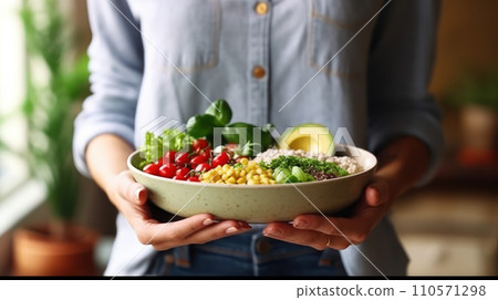 A woman in a t-shirt and jeans standing and holding a vegan food A woman in a t-shirt and jeans standing and holding a vegan food 110571298