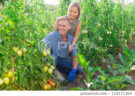 Father and daughter having fun in garden 110571364