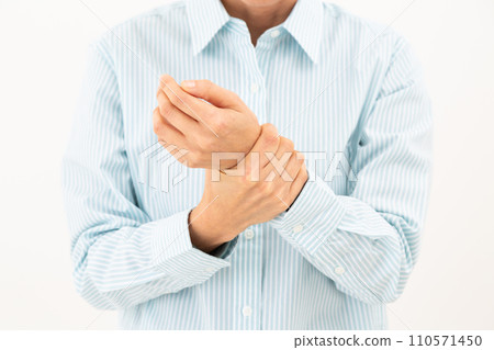 Middle-aged woman holding her wrist 110571450