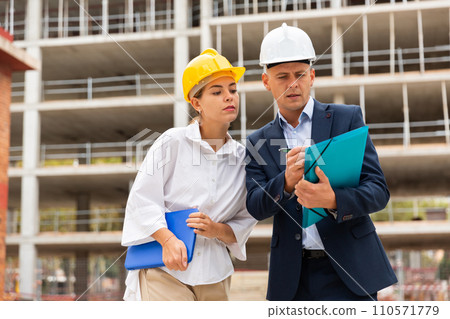 Civil engineers checking work process in construction site 110571779