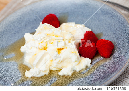 Catalan whey cheese, mato, served on plate with raspberries and honey Catalan whey cheese, mato, served on plate with raspberries and honey 110571868