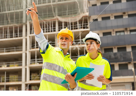 Civil engineers checking work process in construction site 110571914