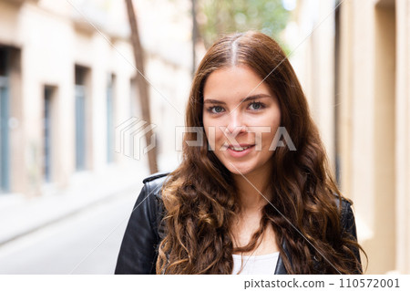 Cheerful attractive female walking on street outdoor 110572001
