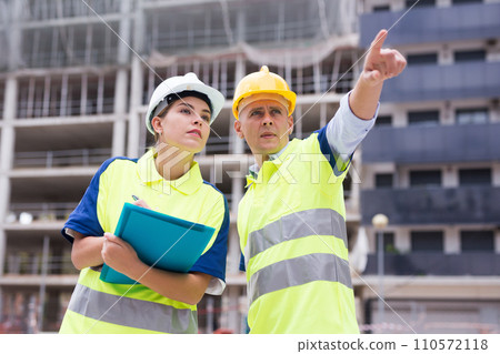 Civil engineers checking work process in construction site 110572118