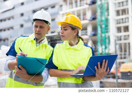 Male and female engineers in construction area 110572127