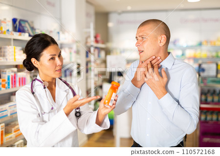 Man asks to help pharmacist choose medicine for toothache Man asks to help pharmacist choose medicine for toothache 110572168