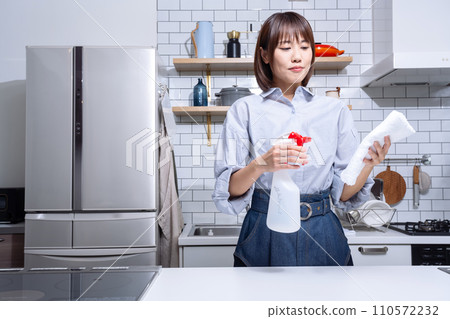 A woman cleaning the kitchen A woman cleaning the kitchen 110572232