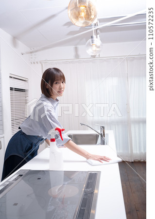 A woman cleaning the kitchen 110572235