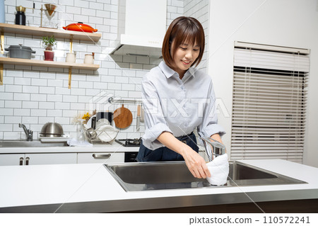 A woman cleaning the kitchen A woman cleaning the kitchen 110572241