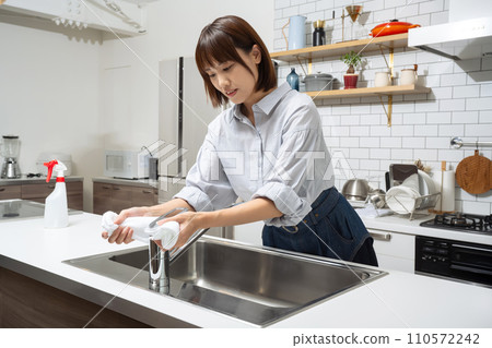 A woman cleaning the kitchen A woman cleaning the kitchen 110572242
