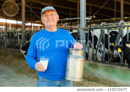 Senior farmer in cowhouse 110572677