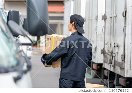 young man standing in front of a truck 110576352