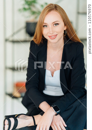 portrait of a Beautiful businesswoman with long red hair in black business suit. portrait of a Beautiful businesswoman with long red hair in black business suit. 110576970
