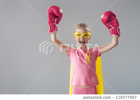 Child in boxing gloves with a yellow ribbon 110577487