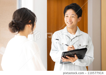 A housewife listening to a man in work clothes at a remodeling/equipment shop/construction shop (inspection) 110577914
