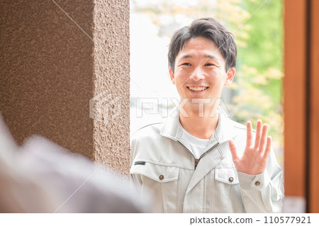 A young man in work clothes greets his wife on his way to work 110577921
