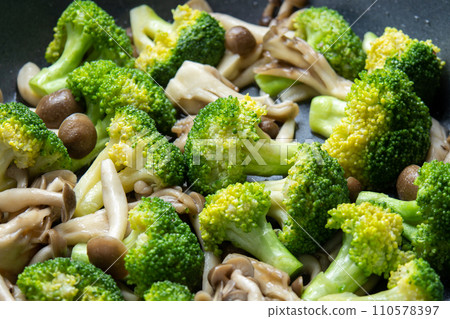 Stir-fried broccoli and mushrooms (bunashimeji mushrooms and maitake mushrooms), cooking scene. 110578397