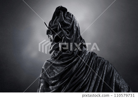 Creepy figure with animal horned skull over dark misty background Creepy figure with animal horned skull over dark misty background 110579731