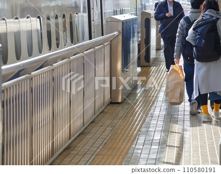Shinkansen cars and passengers preparing to depart on the Nagoya Station platform 110580191