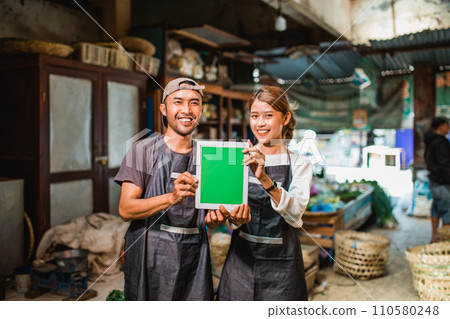 couple asian vegetable seller holding green screen tablet 110580248