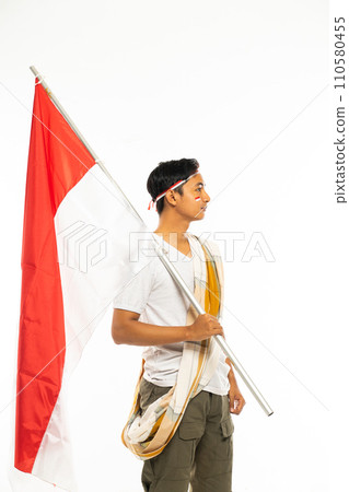 a handsome man standing bring a stick with indonesian flag on it 110580455