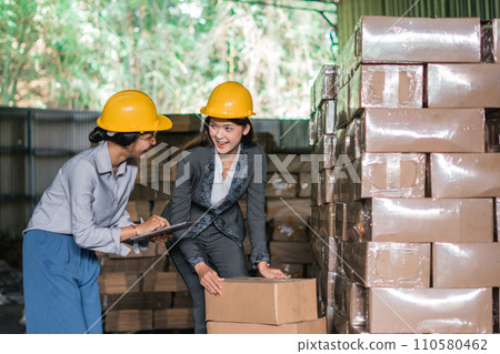 female factory employees check the contents of the boxes with data 110580462