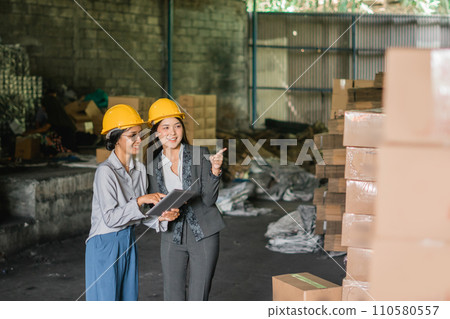two Asian women factory employees checking and pointing at goods two Asian women factory employees checking and pointing at goods 110580557