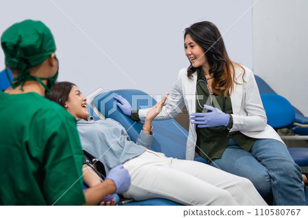 female donor chatting and consulting with female doctor during blood donation female donor chatting and consulting with female doctor during blood donation 110580767