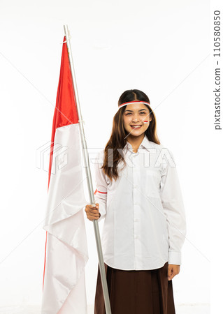 a beautiful asian woman standing bring the indonesian flag and smiling a beautiful asian woman standing bring the indonesian flag and smiling 110580850