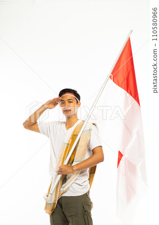a man standing with salutation and Indonesian flag at his hand 110580966